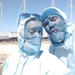 Ramon and Lotte applying antifouling paint while maintaining their liveaboard sailboat in a boatyard.