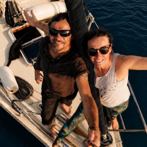 Ramon, Lotte and their black cat Styx aboard their liveaboard sailboat Mutiny during their sailing adventures.