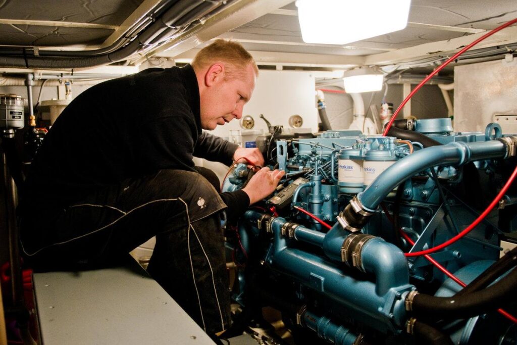 Marine diesel mechanic working in a yacht engine room