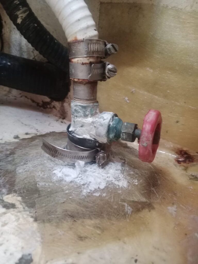 Improvised emergency repair on Mutiny’s leaking seacock using butyl tape, neoprene and a hose clamp